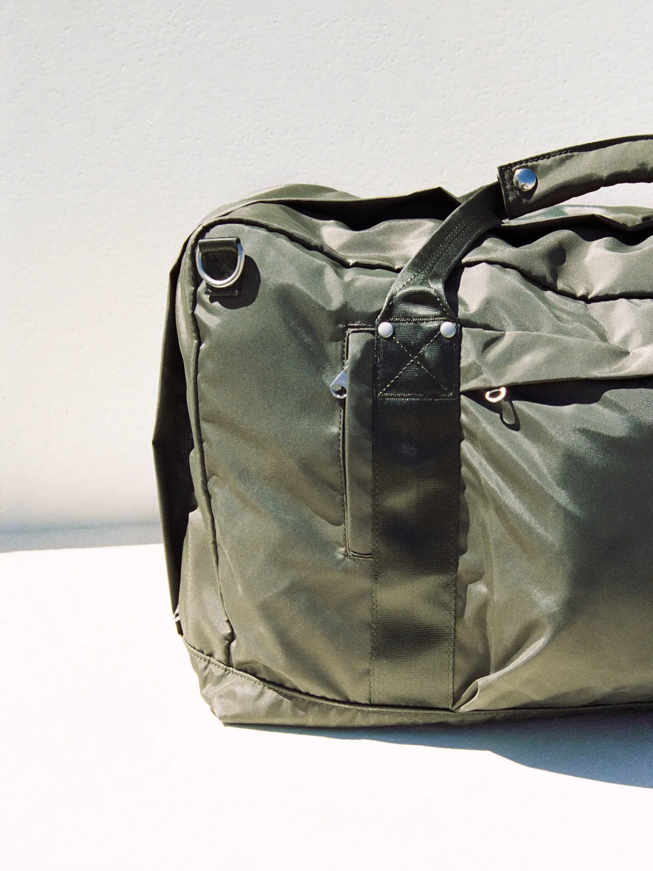 Olive travel bag placed against a light background.