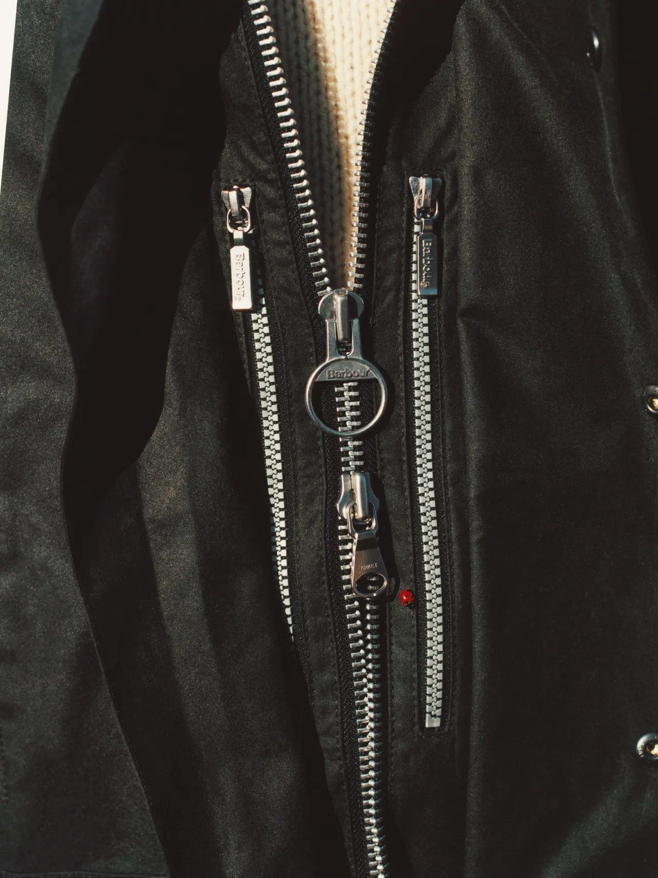 Close-up of a wax jacket zipper and fabric texture.